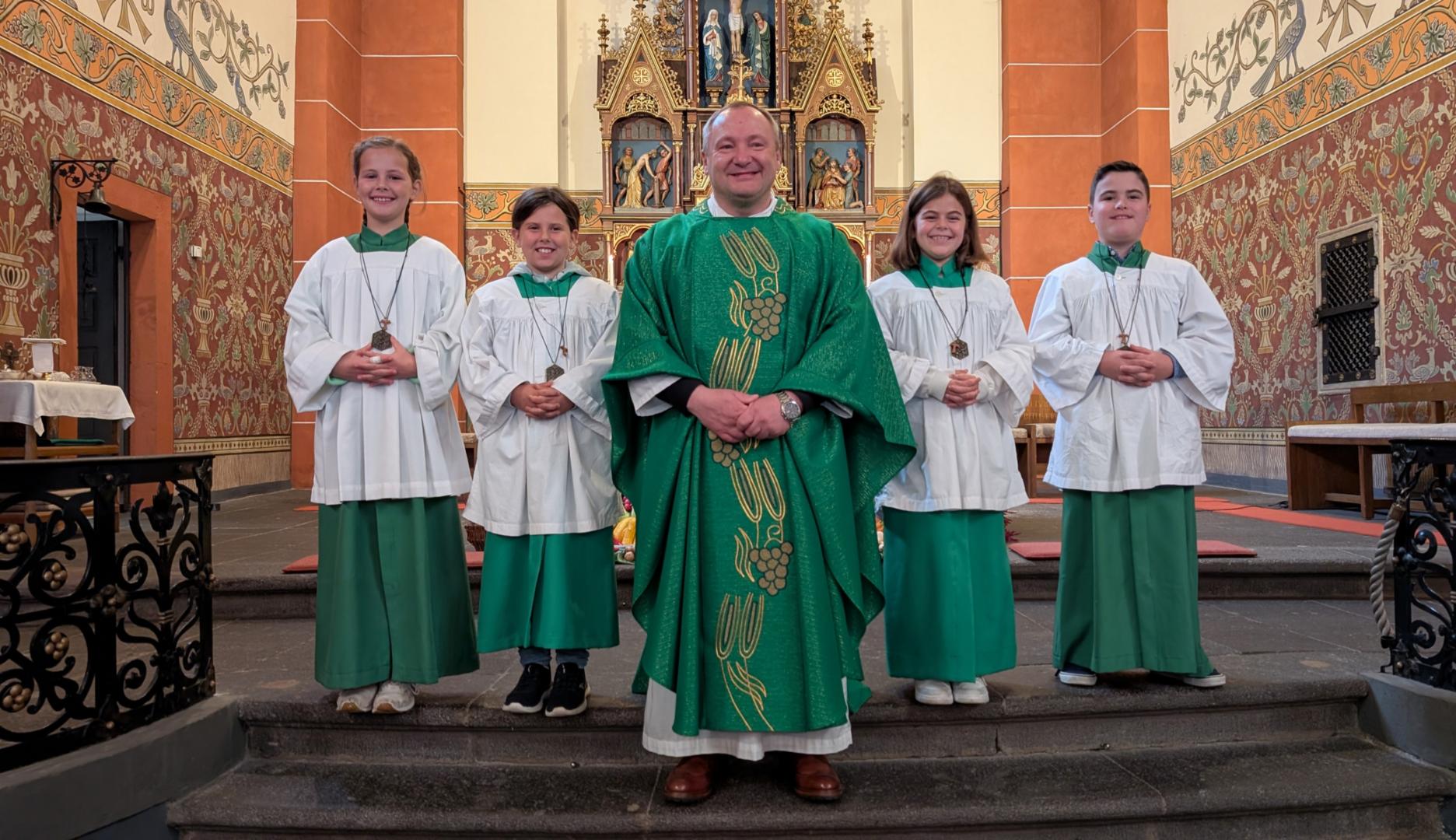 Drei neue Messdienerinnen und ein neuer Messdiener. V.l.n.r.: Mila Risser, Charlotte Brohl, Kooperator Konrad Lisowski, Charlotte Timm, Jonathan Pilcher