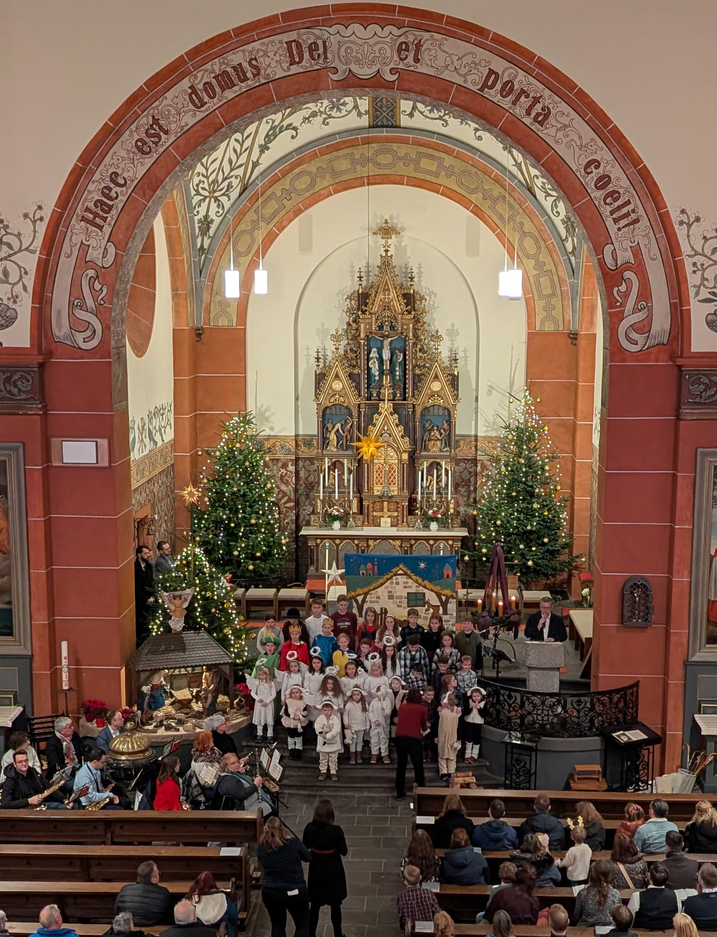 Das Bild zeigt alle Kinder am Ende des Krippenspiels im Altarraum der Kirche
